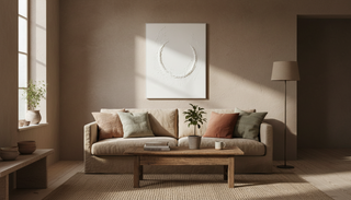 A white contemporary art created with plaster and paint sits on a brown wall in late afternoon sun.